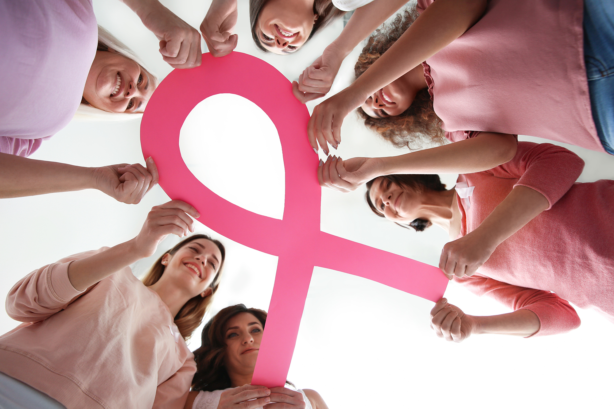Women holding pink paper ribbon, bottom view Breast cancer awar